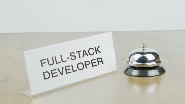 Full-Stack Developer Office or Room with Hand Ringing The Bell on Desk or Table Multiple Times