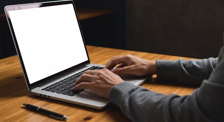 Close-up image of a man working on laptop computer at a table, typing on the laptop keyboard. the laptop with a white screen mockup

