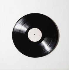 Obraz premium Black Vinyl Record with Worn White Label on Plain White Background