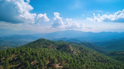 Lush green hills meet a clear blue sky with fluffy clouds in the distance
