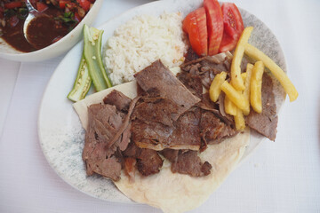top view of lamb doner kebab, rice and chips on a plate 