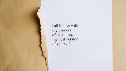 A torn beige paper partially covers a white sheet with the motivational text "Fall in love with the process of becoming the best version of yourself" in sans-serif font. Simple and inspiring design.

