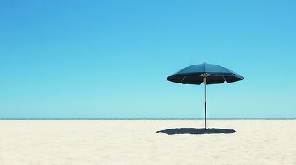 A wide shot of a beach umbrella casting a shadow on the sand, with a perfect blue sky overhead.
