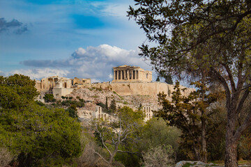 Fototapeta premium Majestic Parthenon on a mountain among the trees, with a blue sky in the background, Athens, Greece