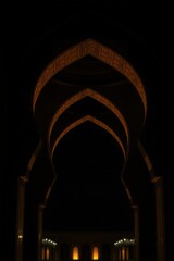 Fototapeta premium Islamic arch at night, high-definition. Dark and gold tones, detailed focus, pure black, deep shadows, architectural art style 
