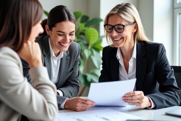 Team of Professional Businesswomen Engaging in Collaborative Discussion Over a Document in a Bright Office Environment