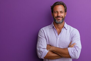 A confident man with a beard poses against a vibrant purple background, arms crossed.