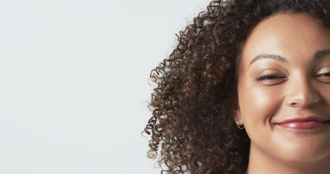 Smiling plus size woman with curly hair showing only half of her face against white background, copy