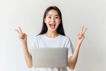 A joyful young woman holding a laptop and making peace signs.