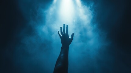 Hand reaching for light in smoky darkness