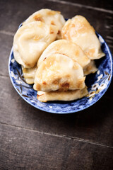 Dumplings with potato and cottage cheese stuffing (pierogi). Wooden background. Copy space.	
