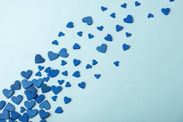 Blue hearts scattered across a pale blue or sky blue background creating a sense of movement and energy, playful scene, vibrant colors, blue hearts
