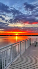 Obraz premium Balcony Overlooks a Vibrant Sunset Reflected on Water with Colorful Sky