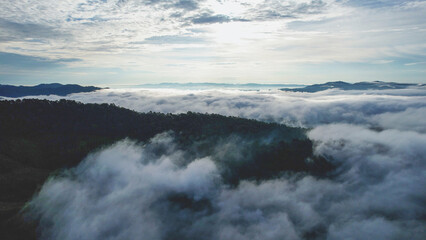 Aerial landscape view of the sea of fog flowing on hills by drone