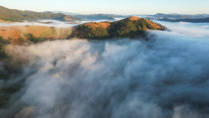 Aerial landscape view of the sea of fog flowing on hills by drone