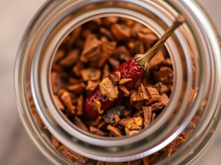 Close-up of single dried Kashmiri chilli seed and flake in a small glass jar, food seasoning, flavoring, kashmiroiled chilli