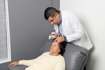 Elderly Latin woman undergoes EEG electroencephalogram to detect dementia or Alzheimer's disease in...