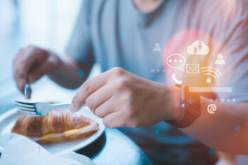 man sitting in cafe wearing smart watch with speed bubbles and virtual icons in concept of social media and technology