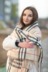 Fototapeta premium Beautiful young dark-haired girl in an urban environment in early spring.
