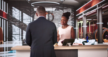 Woman At Hotel Talking To Receptionist Man