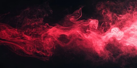 Fototapeta premium Dynamic red smoke swirling on a black background creates a striking visual effect. This motion of red smoke against the dark backdrop enhances the dramatic appeal of the composition.