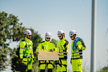 Team of workers planning at a construction site in bright safety gear during a sunny day