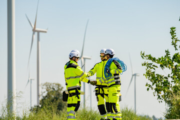Professionals collaborate at a wind farm site during bright daylight to enhance energy production...