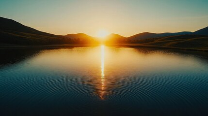 Sunset over still lake and mountain range