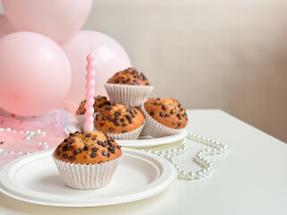 Chocolate chip muffins with candle and pink balloons for celebration. Birthday concept