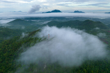Aerial view fog in the forest and mountains and the transmission towers. Repeater station.