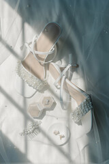 Flatly of bridal pearl heels and jewelry covered in veil.