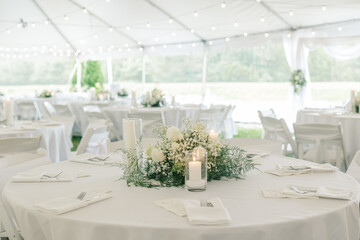 Elegant wedding reception setup with floral centerpiece and candles.