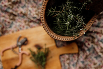 a woven basket with fresh herbs inside on a wooden board