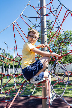 Teenager boy playing on the rope playground