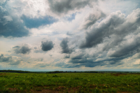 Open sky with storm clouds over tall grass prairie