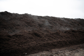 Steam rises from a row of commercial organic compost