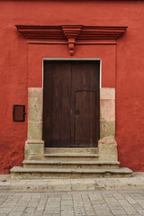 Red facade of colonial building in historic center of Oaxaca, Mexico