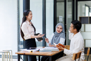 Financial Advisor discussion group of four happy young asian corporate people teammates meeting discussing business in the workplace office.
