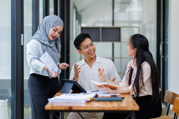 Financial Advisor discussion group of four happy young asian corporate people teammates meeting discussing business in the workplace office.
