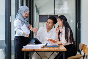 Financial Advisor discussion group of four happy young asian corporate people teammates meeting discussing business in the workplace office.
