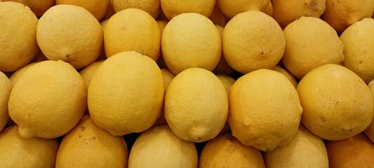 yellow lemons on the supermarket fruit shelf