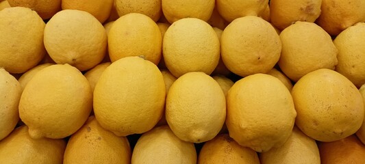yellow lemons on the supermarket fruit shelf