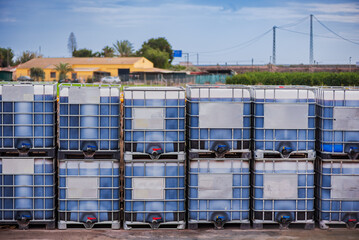 Containers for the transport of liquids, also called CGEM under the ADR code for dangerous goods, stacked and filled with liquid.