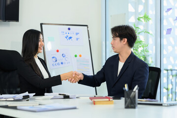 Two professionals businesspeople shaking hands in an office after successful agreement or collaboration