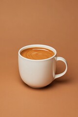 Creamy coffee in simple white cup contrasts beautifully with war