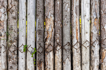Old grungy dark wooden fence made of slab boards