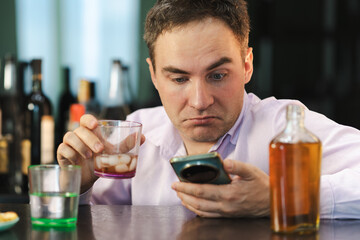 An unemployed specialist who got drunk alone out of boredom is quarantined in self-isolation. alcoholism, alcohol addiction and people concept - male alcoholic with bottle rum at home