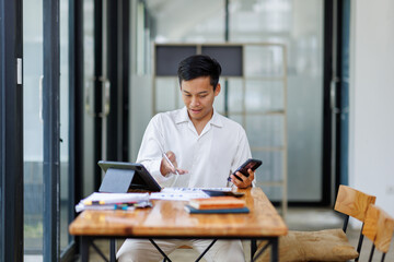 Portrait of young Happy excited asian business man in office working with mobile phone,Yes great job.