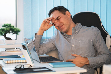 the concept of hunger at work, rumbling in the stomach, a sick employee. businessman having a...