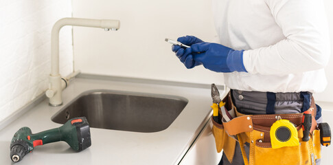 Male Plumber In Overall Fixing Sink